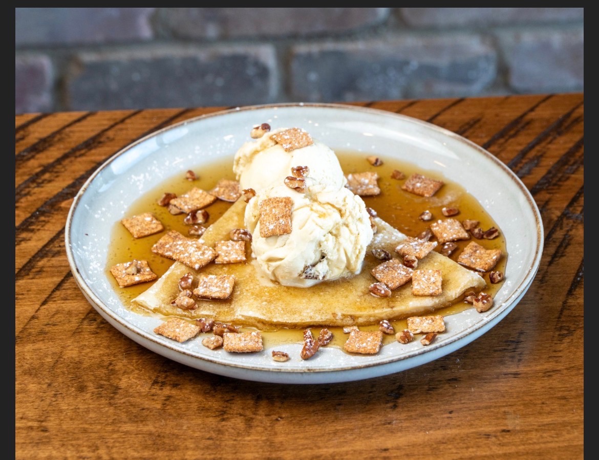 Crepe topped with vanilla ice cream, cinnamon cereal and maple syrup